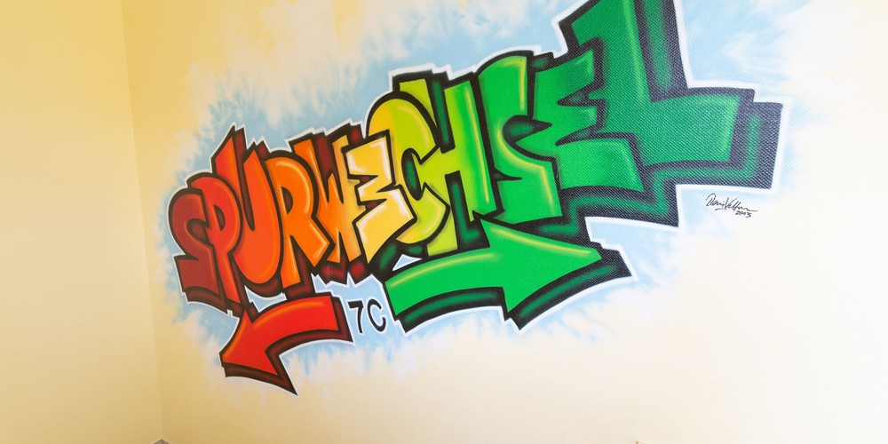 Das Bild zeigt ein Graffiti in einem Flur. In bunten Buchstaben steht das Wort "Spurwechsel" geschrieben. Das Bild zeigt ein Graffiti in einem Flur. In bunten Buchstaben steht das Wort "Spurwechsel" geschrieben.